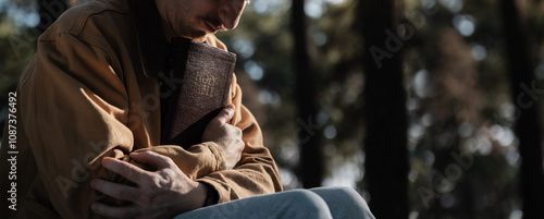 Christian read and pray with holy bible in forest with Holy light shining. Pray to God to confess your sins and ask for blessings to overcome his problems. faith, and religion.