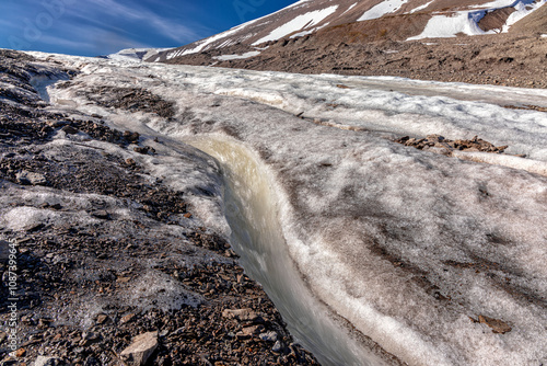 Gletscherschmelze in Longyearbyen im Sommer.  Das geschmolzene Eis läuft in kleinen Bächen den Berg hinab. Norwegen,Polarkreis. photo