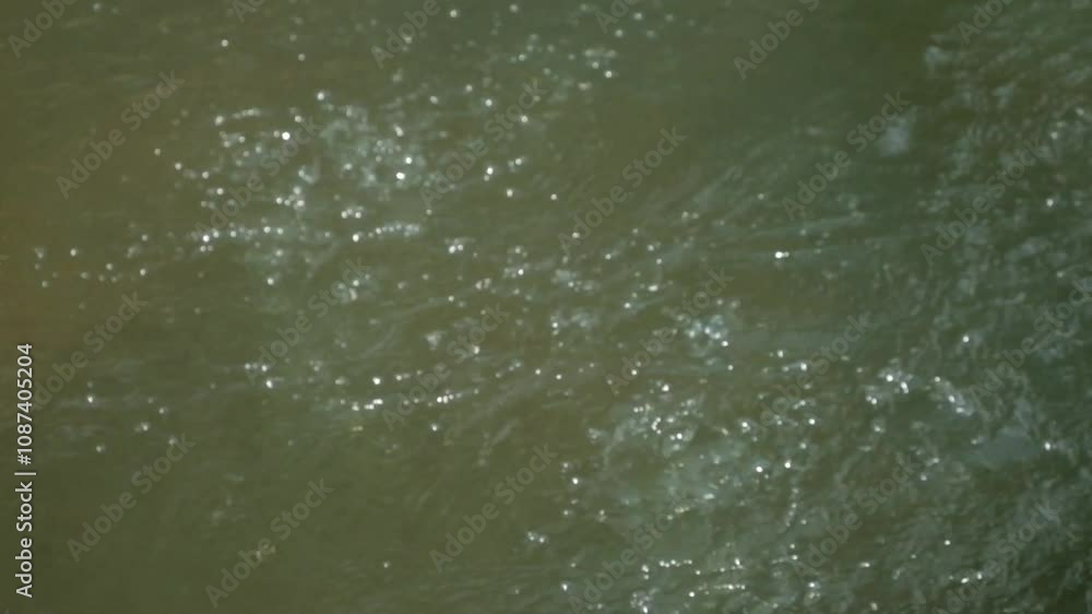 Close up water bubbles from a clear river spring. The river water is clear and looks natural. The bubbling river surface with abstract patterns and textures. Nature and environmental concepts