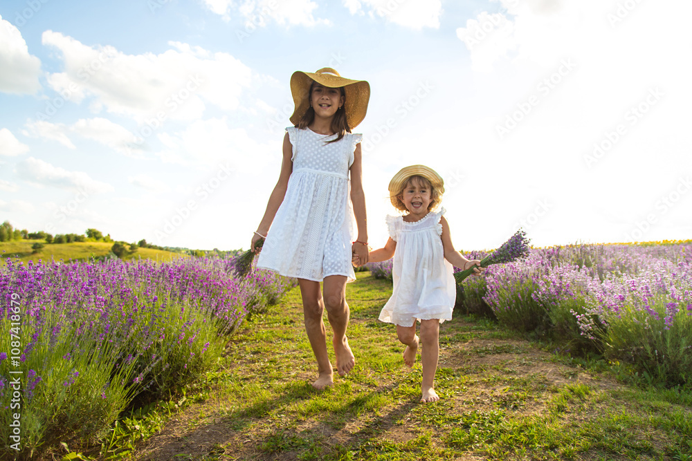 Fototapeta premium Child girl in lavender field. Selective focus.