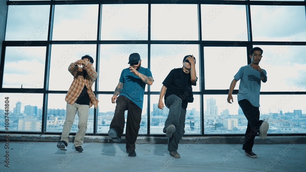 Obraz premium Group of multicultural dancer dancing together with skyscraper. Portrait of multicultural hipster team moving foot step with confident near window with urban city view. Outdoor sport 2024. Hiphop.