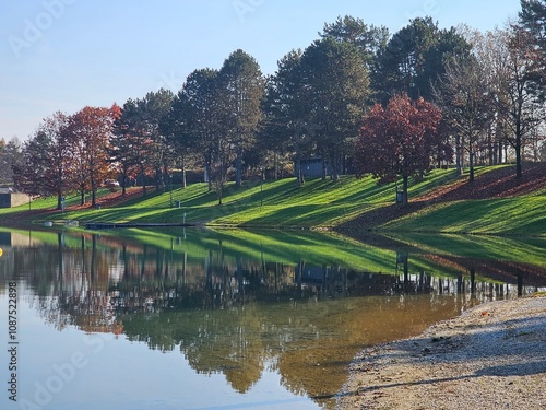 Obraz na płótnie Wunderschöne Spiegelung von Böschung, Bäumen und Rasen in See im Herbst w salonie