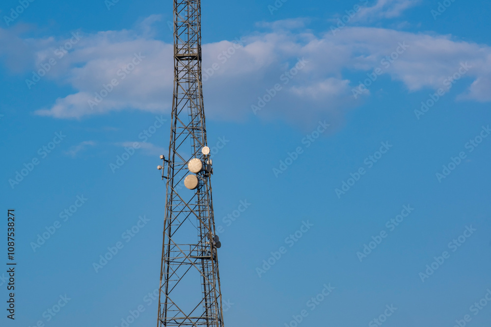 The communication tower of the mobile operator. View of the telecommunication equipment and antennas installed on the communication tower. The communication tower of the mobile operator. View of the telecommunication equipment and antennas installed on the communication tower.