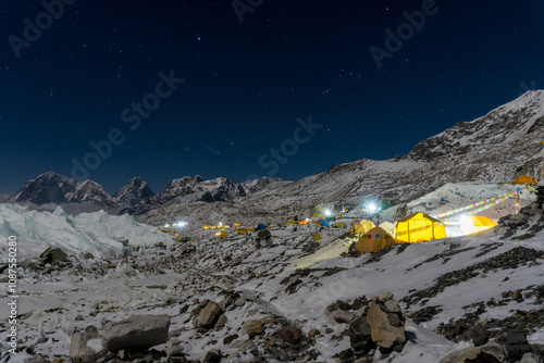 Night time sky over Everest base camp on Khumbu glacier. Tents are lit with lights from inside. Nepal.