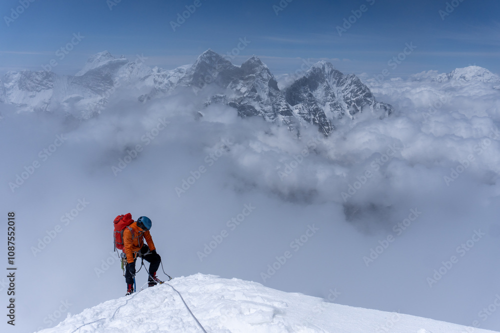 Man wearing a orange jacket, summitting Ama Dablam, feeling tired. Khumbu region, Nepal. Man wearing a orange jacket, summitting Ama Dablam, feeling tired. Khumbu region, Nepal.