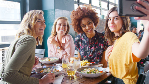 Group Of Young Female Friends Posing For Selfie In Restaurant Before Eating Meal photo