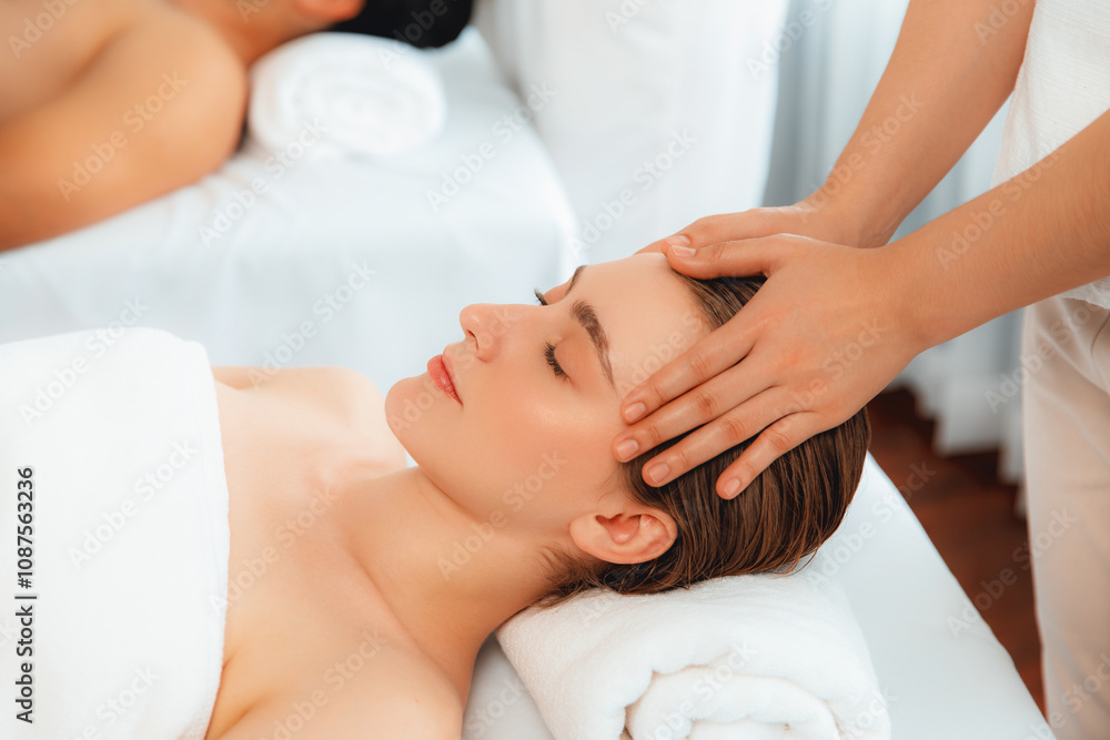 Fototapeta premium Caucasian couple enjoying relaxing anti-stress head massage and pampering facial beauty skin recreation leisure in dayspa modern light ambient at luxury resort or hotel spa salon. Quiescent