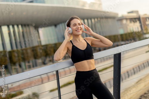 Young woman enjoys jogging by the riverside while listening to music, embracing a healthy lifestyle in the morning sun