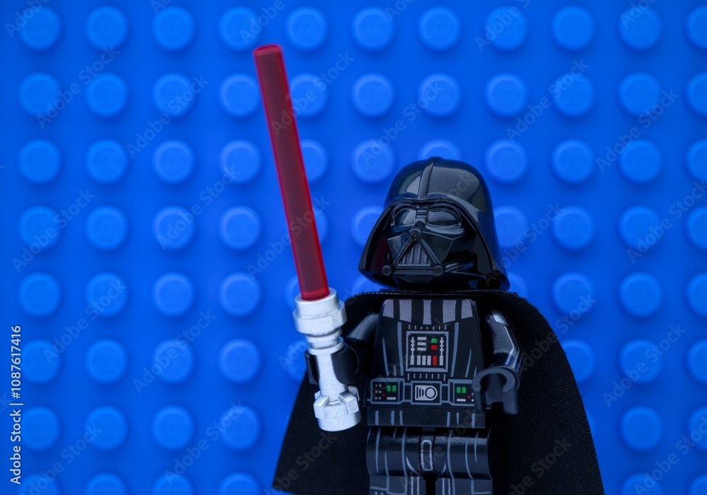Obraz premium Tambov, Russian Federation - November 14, 2024 Portrait of Lego Darth Vader minifigure with lightsaber against a blue baseplate background