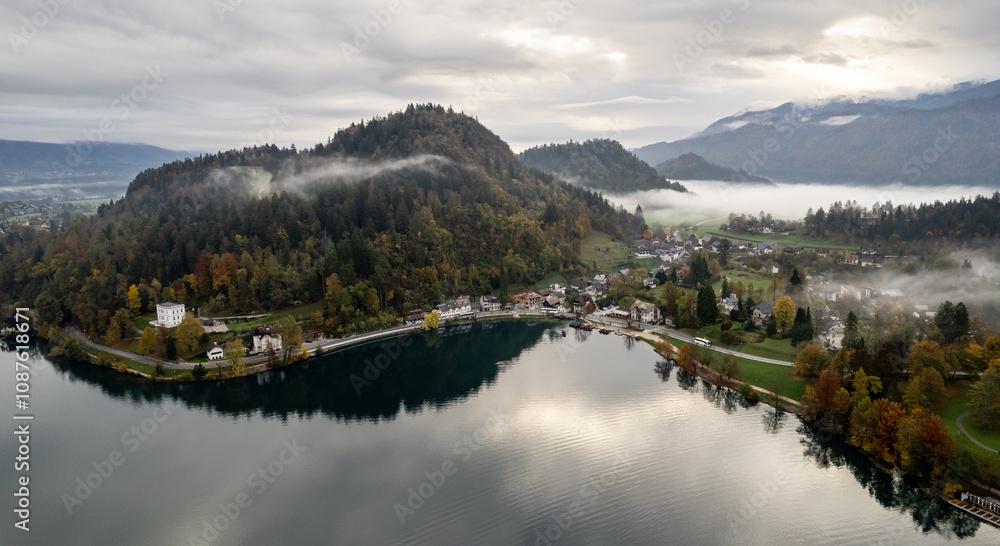 Fog covering lake bled in slovenia on a cloudy autumn day. Julian apls in the background Fog covering lake bled in slovenia on a cloudy autumn day. Julian apls in the background