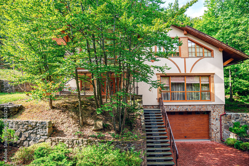 Wooden house in green forest in summer day.