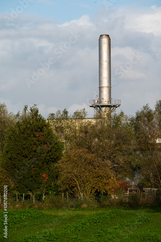 Industrial chimney of water cleaning plant and green surroundings of the river Senne in Lot, Flemish Brabant, Belgium photo