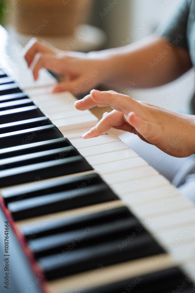 Fototapeta premium A talented pianist gracefully plays a beautiful melody, their hands gliding over the keys, producing enchanting music that fills the room and creates a captivating atmosphere