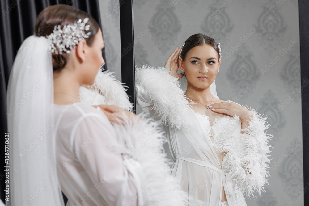 A woman in a white gown is standing in front of a mirror, adjusting her hair. Concept of elegance and sophistication, as the woman is dressed in a wedding gown and is preparing for a special occasion