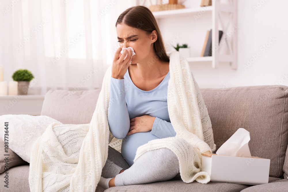 Pregnancy And Cold. Sick Pregnant Lady Blowing Nose In Tissue Feeling Unwell Sitting On Couch At Home Pregnancy And Cold. Sick Pregnant Lady Blowing Nose In Tissue Feeling Unwell Sitting On Couch At Home