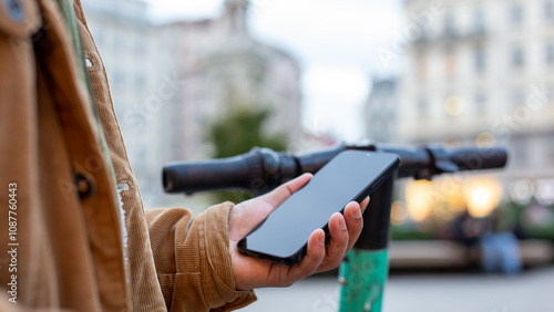 Tourist using smartphone app for renting electric scooter in city center