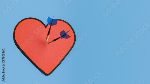 Two darts hitting red heart shaped target on blue background