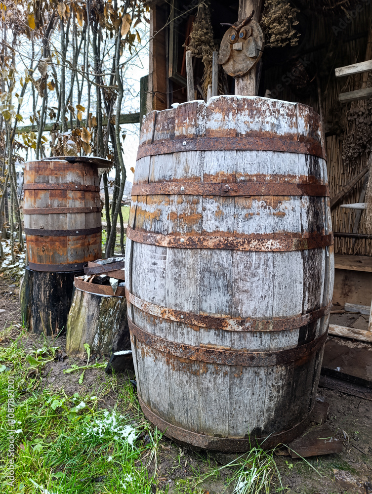A couple of wooden barrels sitting next to each other in front of a building A couple of wooden barrels sitting next to each other in front of a building