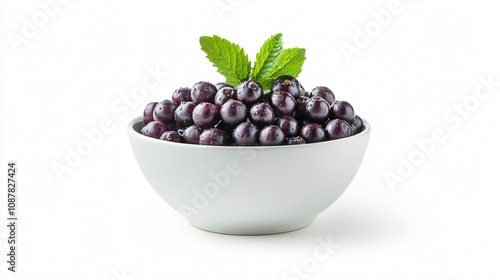 A bowl of elderberries with a sprig of mint, isolated on a clean white background with soft shadows photo