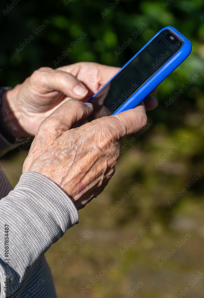 Elderly Hands Typing on Mobile Phone