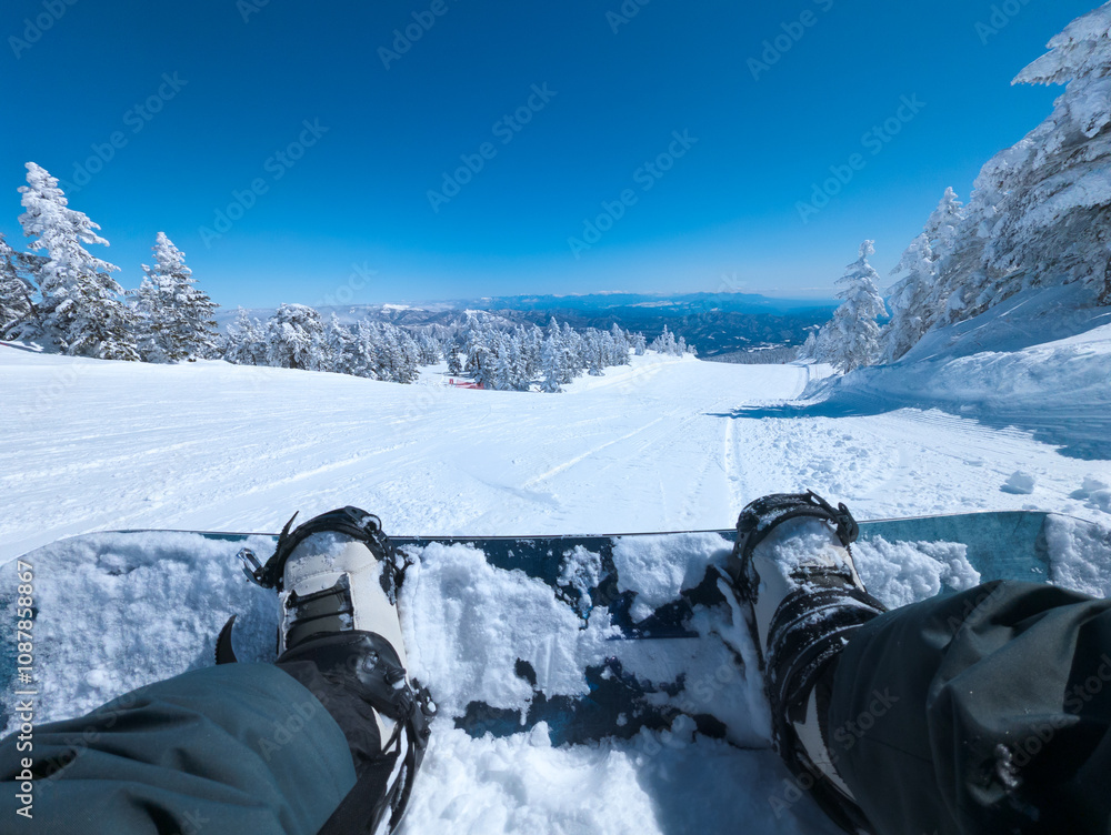 First person view of a snowboard at the top of a ski slope in Shibutoge, Japan
