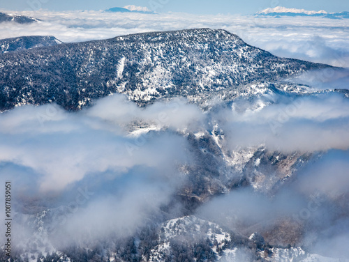 Snowy mountains and forests shrouded in a layer of cloud (Yokoteyama, Nagano, Japan)[ photo