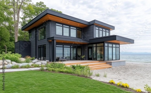 Modern coastal home with expansive glass windows by the serene ocean at twilight