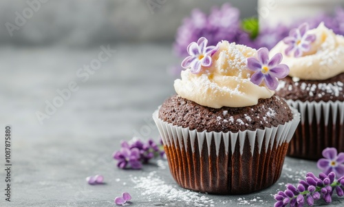 Chocolate cupcakes with lavender frosting and flowers on a gray background