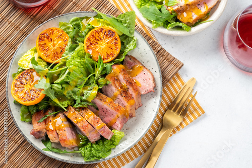 A plate of meat and vegetables with a fork and knife on a table