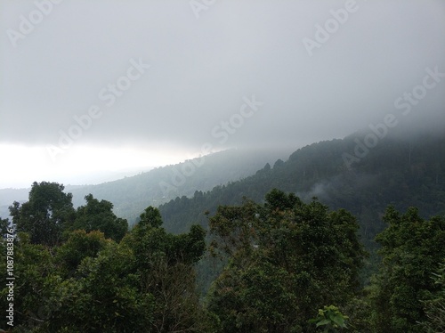 Lush green tropical mountains with a rain cloud at the peak.