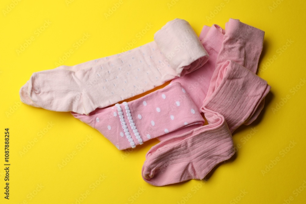 Pink child's tights on yellow background, flat lay Pink child's tights on yellow background, flat lay