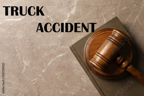 Truck accident law. Wooden judge's gavel and book on marble table, top view photo