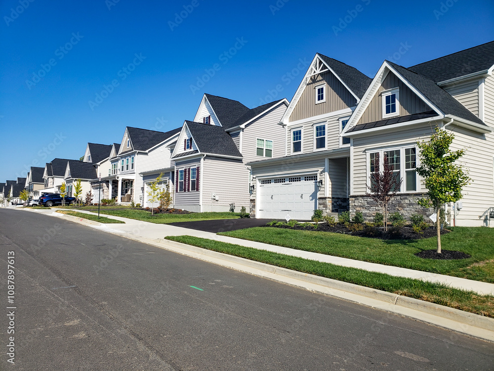 Picturesque street view with modern homes under blue skies. A row of modern detached homes. Picturesque street view with modern homes under blue skies. A row of modern detached homes.