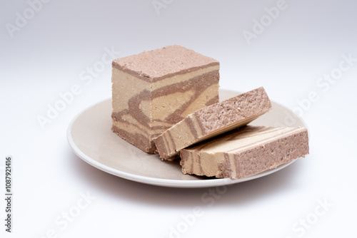 Tahini halva in slices on a white background photo