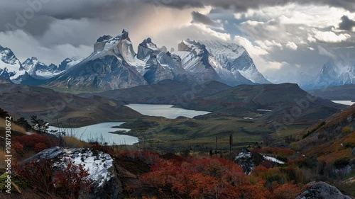 A breathtaking mountain range with dramatic clouds and lakes in autumn colors photo