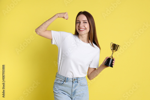 Happy winner with gold trophy cup on yellow background