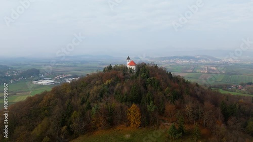 A hilltop church in Slovenia in the autumn looking over the Ljubljana Barje, drone shot, aerial video photo