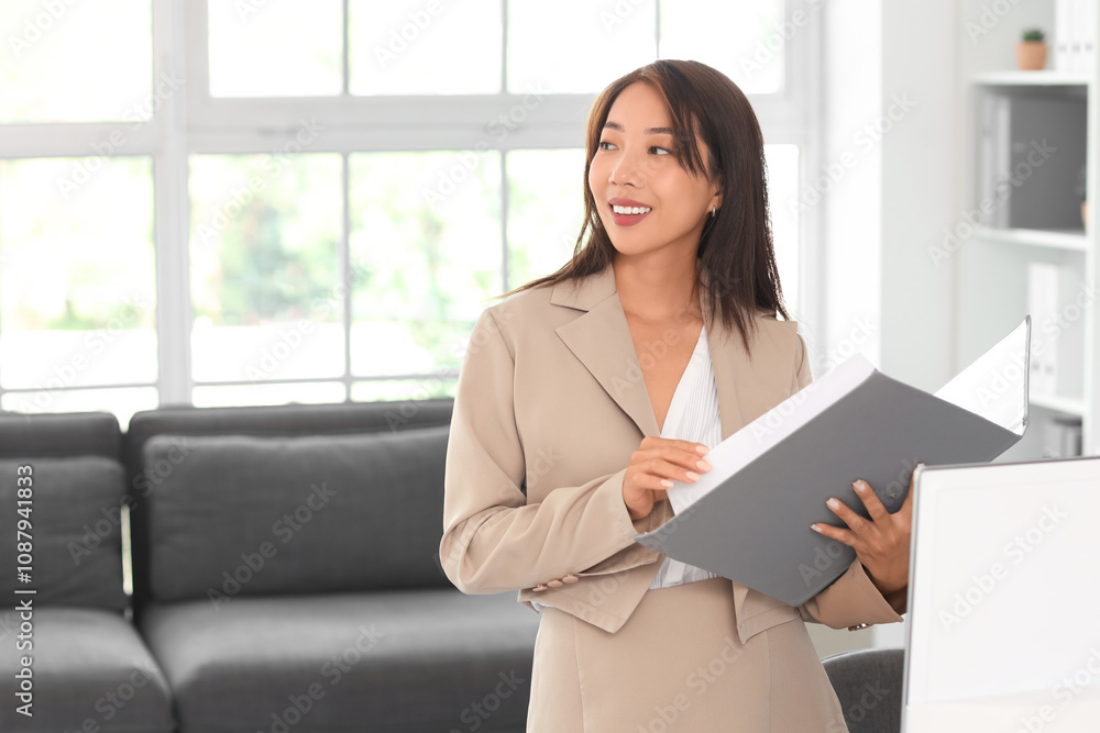 Asian businesswoman with folder in office Asian businesswoman with folder in office