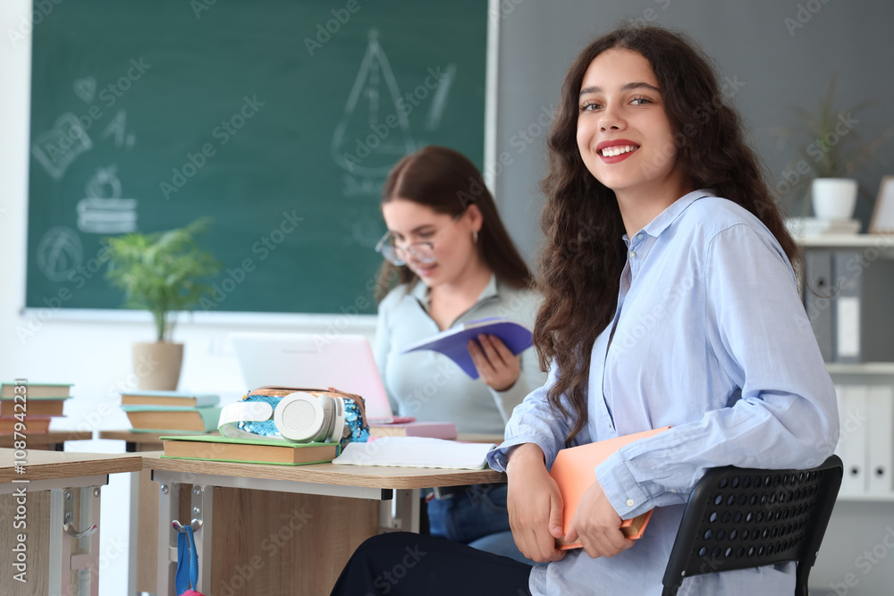 Female student sitting at desk in classroom Female student sitting at desk in classroom