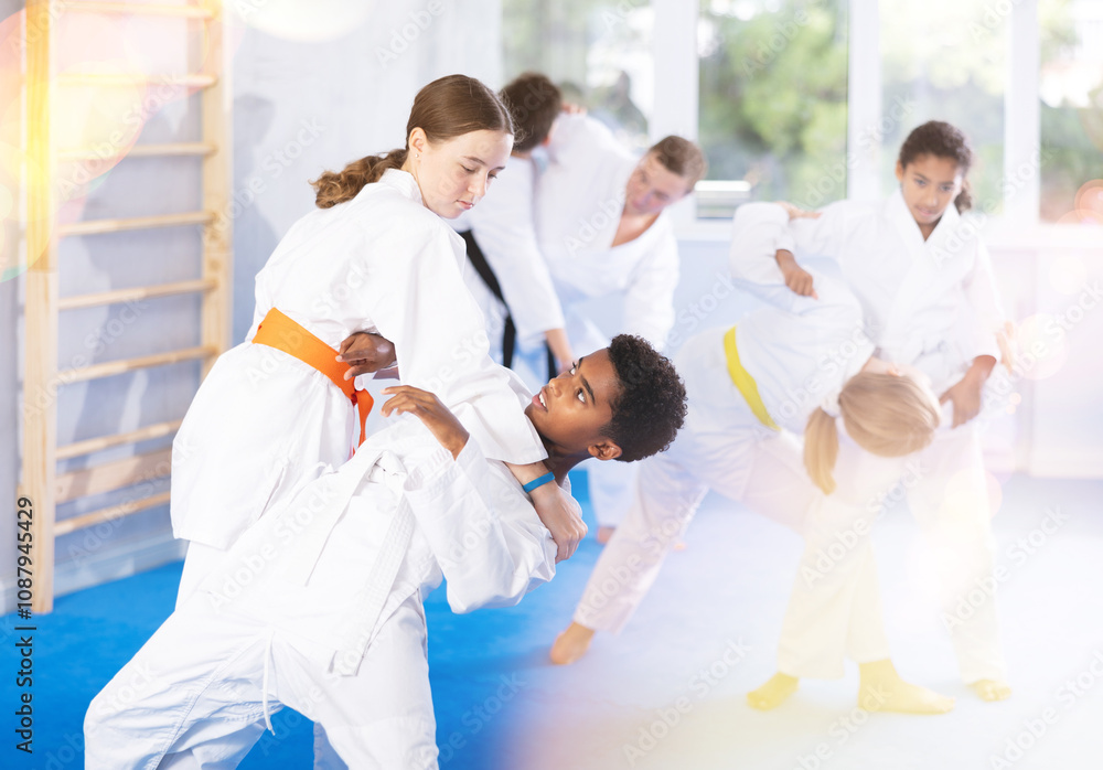 Sparring during karate training of children of different nationalities in gym Sparring during karate training of children of different nationalities in gym