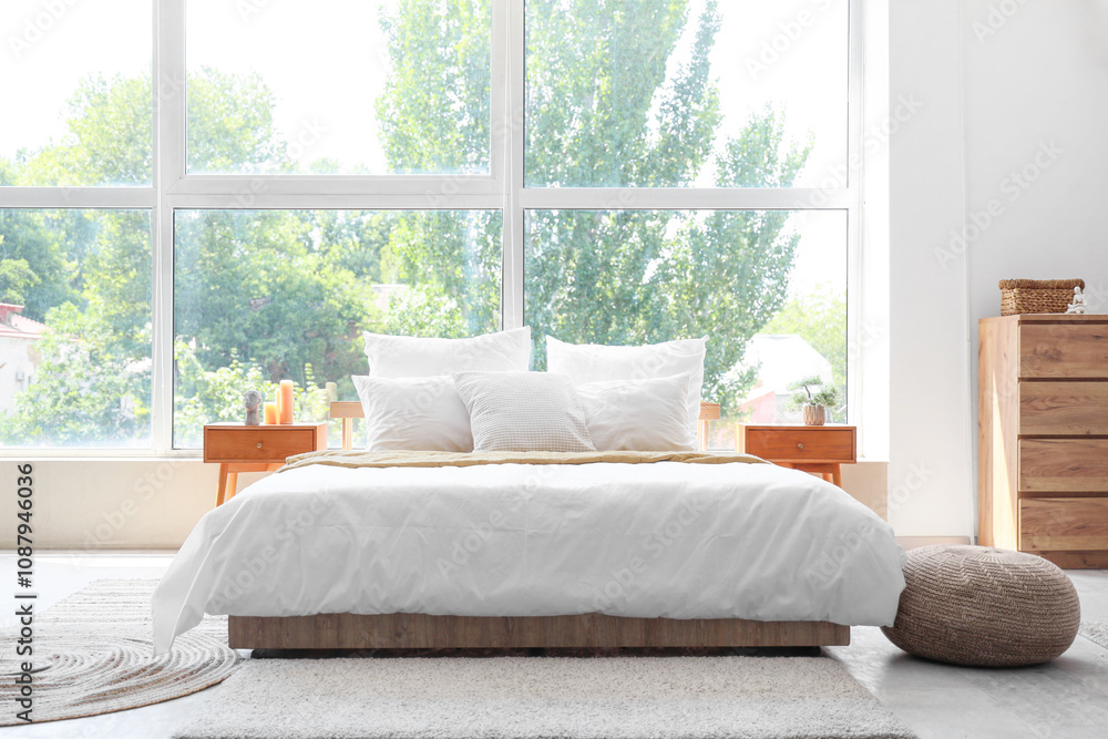 Fototapeta premium Bedroom with big bed, large window, bedside tables and pouf
