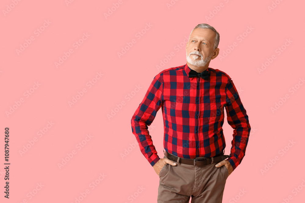 Handsome mature man with stylish bow tie on pink background Handsome mature man with stylish bow tie on pink background
