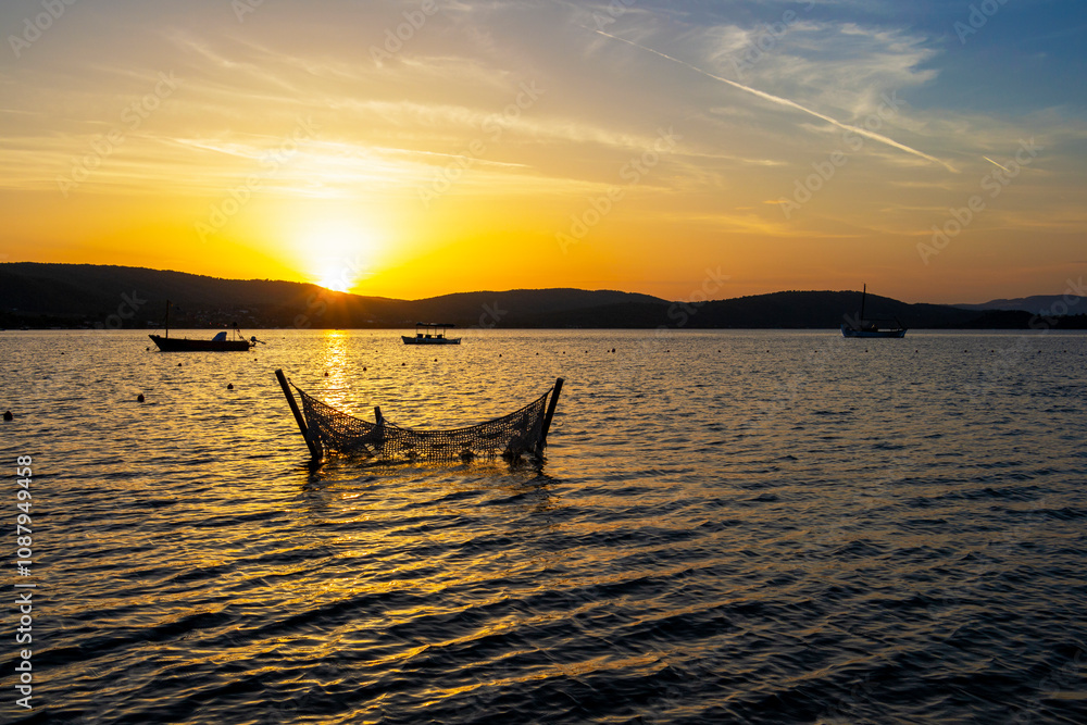Φωτογραφία Sunset at a Vourvourou beach with a fishing net and boats at Sithonia, Chalkidik
