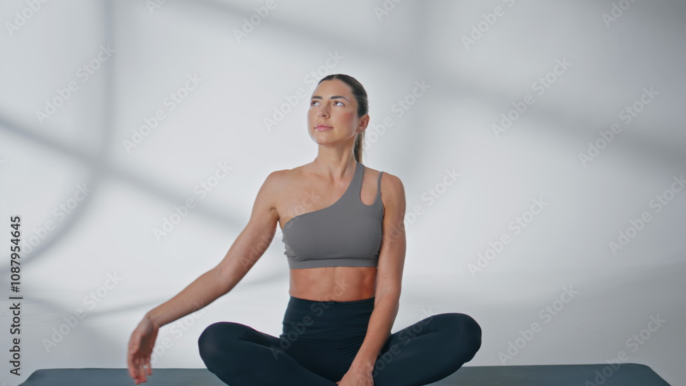 Fototapeta premium Flexible sportswoman stretching sides making yoga exercise for body at morning