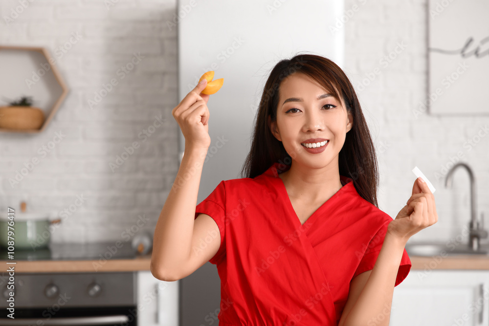 Young Asian woman with fortune cookie and slip at home