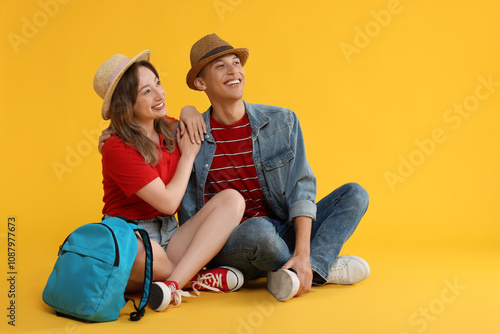 Happy travellers with backpack on yellow background. Space for text