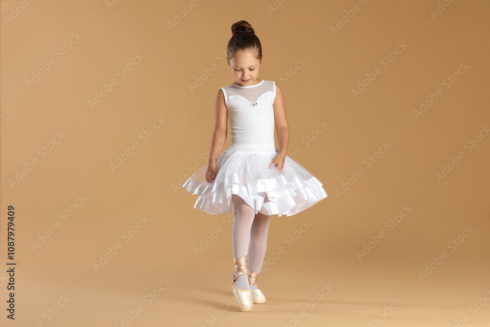 © New Africa - Little ballerina practicing dance moves on beige background © New Africa - Little ballerina practicing dance moves on beige background