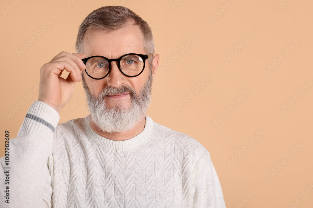 Portrait of senior man in glasses on beige background, space for text Portrait of senior man in glasses on beige background, space for text