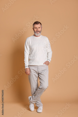 Portrait of senior man on beige background