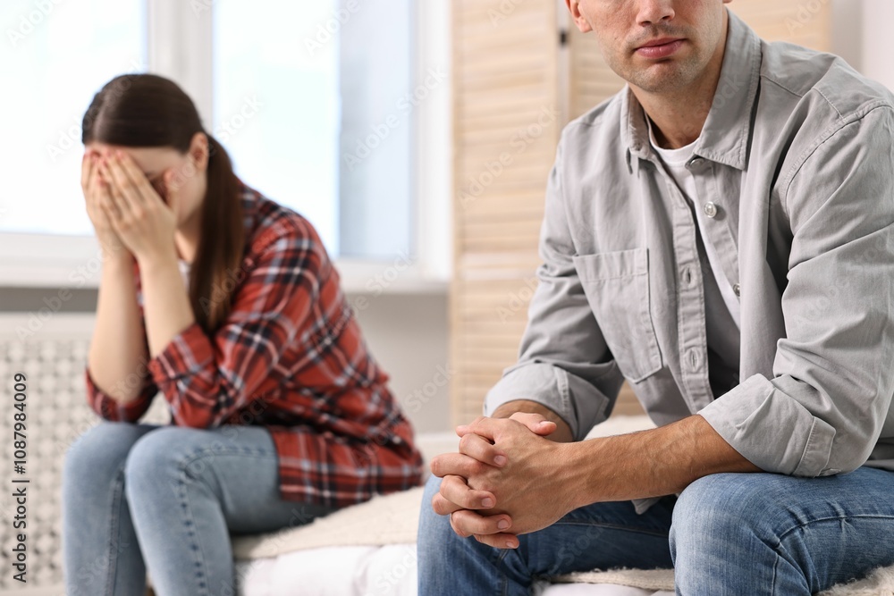 Offended couple ignoring each other at home, selective focus Offended couple ignoring each other at home, selective focus
